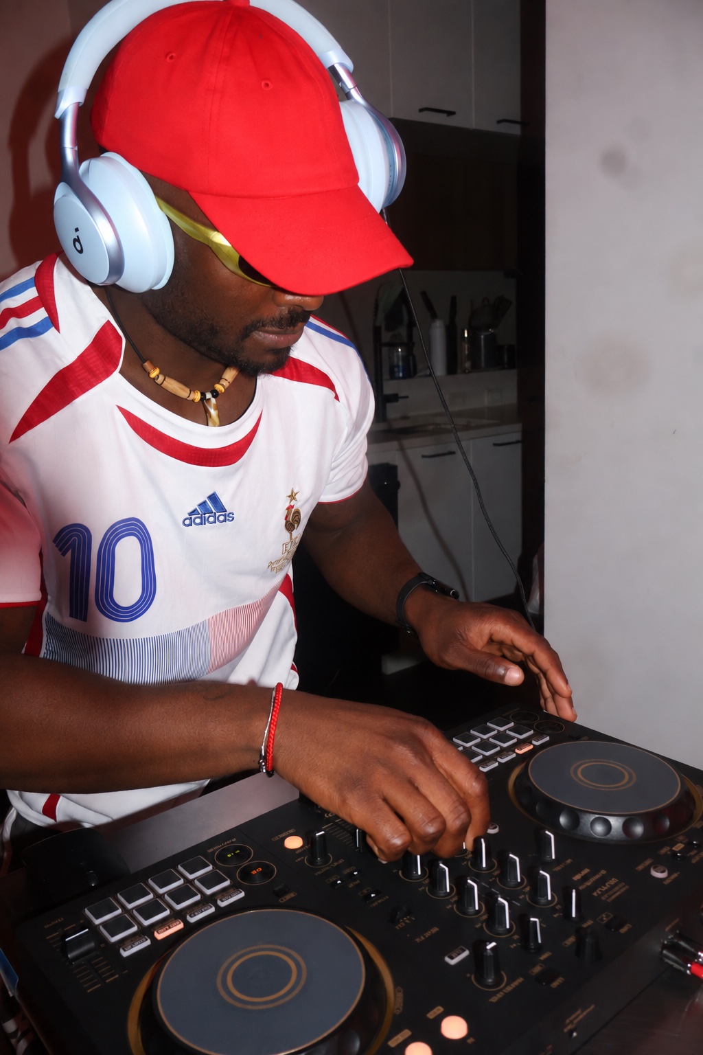 A-WIRE mixing at his DJ controller in a red cap and headphones